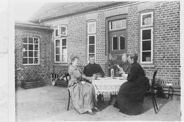 Eine Dersauer Familie sitzt im Hof beim Kartenspielen.