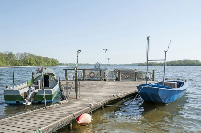 Bootsteg der Fischerei Lasner am Plöner See. 2 Boote sind an dem Steg festgemacht.